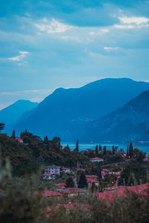 a view of a town with mountains in the background, a picture, inspired by Elsa Bleda, renaissance, lake blue, dusk, vouge italy, landscape mode