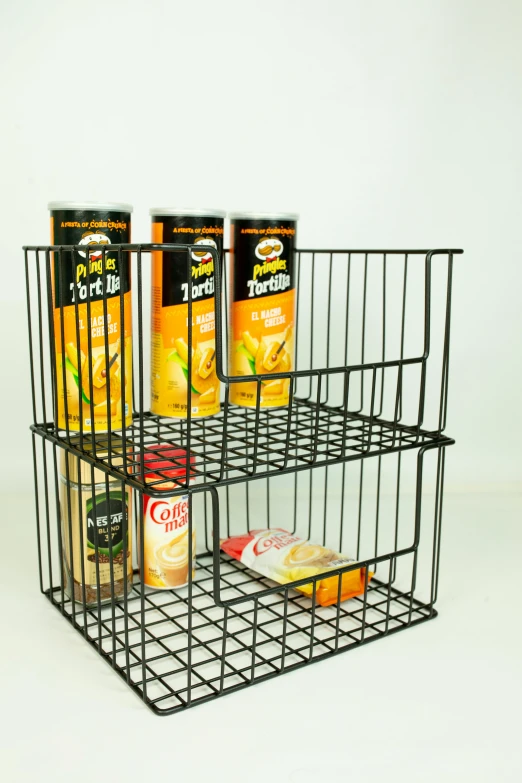 a wire basket that has some food in it, two organic looking towers, cupboards, crisps, all black matte product