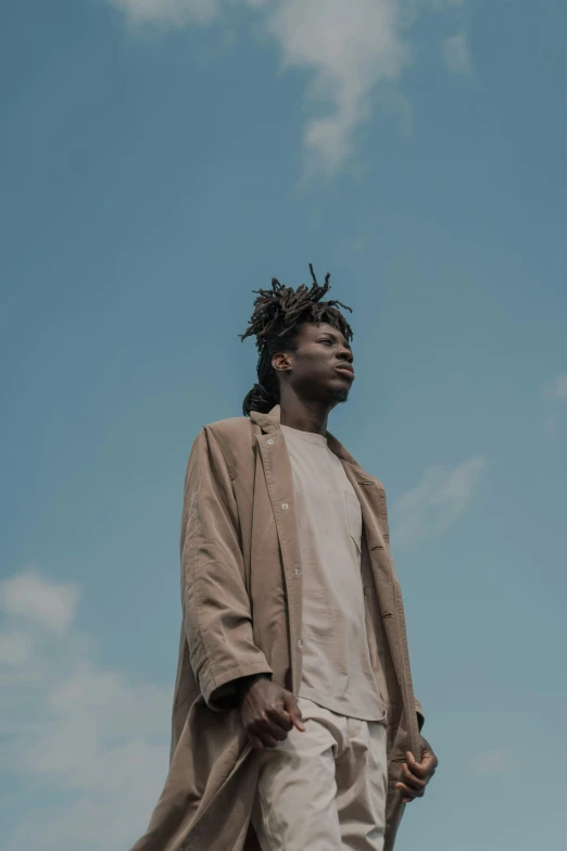 a man with dreadlocks standing in front of a blue sky, pexels contest winner, afrofuturism, cool sepia tone colors, ( brown skin ), 2 1 savage, lean man with light tan skin