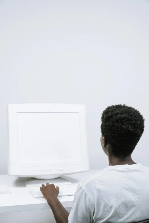 a man sitting at a desk in front of a computer, a computer rendering, pexels, african american young woman, back - shot, whitespace, in front of the internet