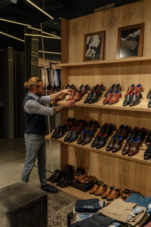 a woman standing in front of a rack of shoes, a photo, by Jan Tengnagel, renaissance, handsome man, official store photo, working, medium close up shot
