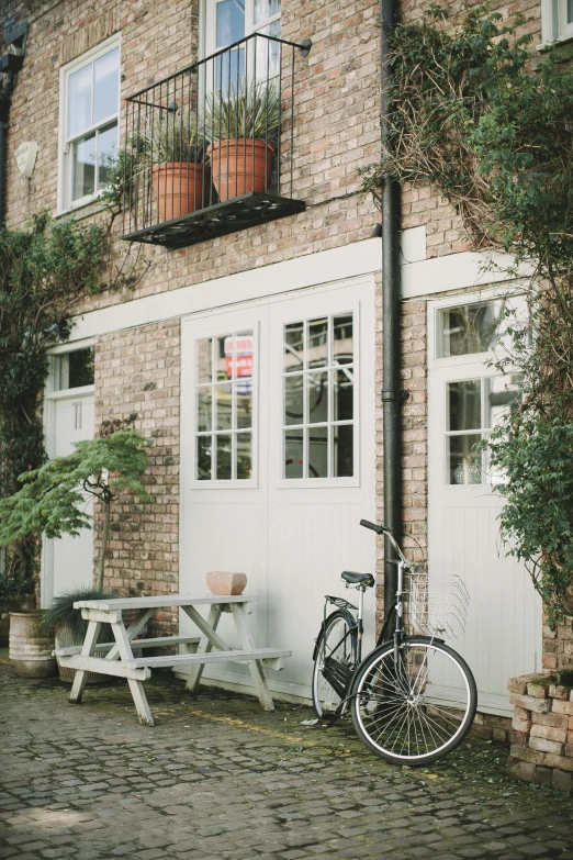 a bicycle parked in front of a brick building, pexels contest winner, visual art, garden at home, white hue, patio, garage