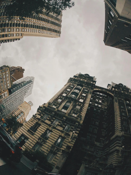 a group of tall buildings sitting next to each other, by Adam Rex, pexels contest winner, gopro photo, grey skies, nyc, worm\'s eye view