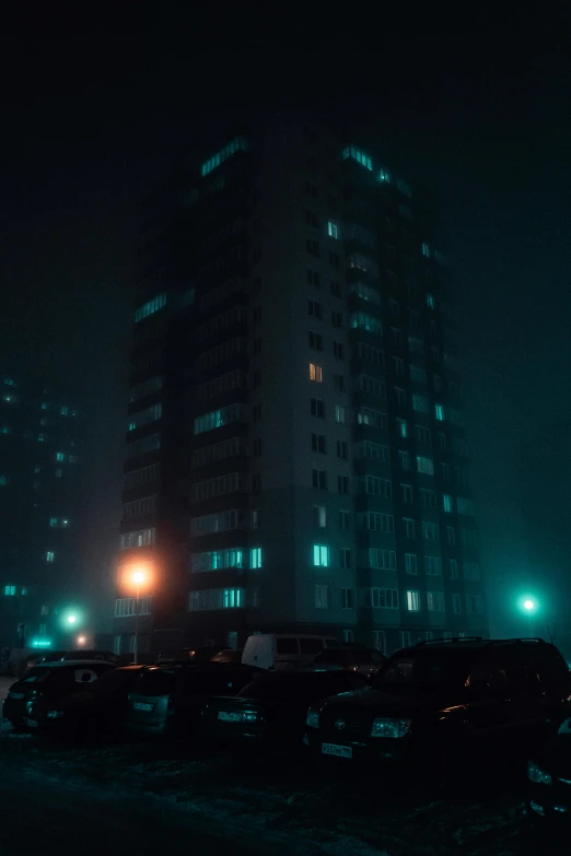 a tall building in the middle of a city at night, an album cover, inspired by Elsa Bleda, unsplash contest winner, realism, cyan fog, soviet apartment buildings, square, high quality photo