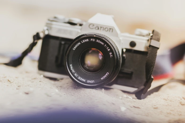 a close up of a camera on a table, a picture, unsplash contest winner, photorealism, canon eos, vintage soft grainy, looking up at camera, camera on the ground