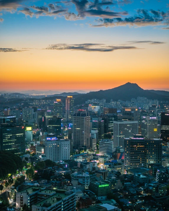 a view of a city with a mountain in the background, kpop, square, at dusk, color photo