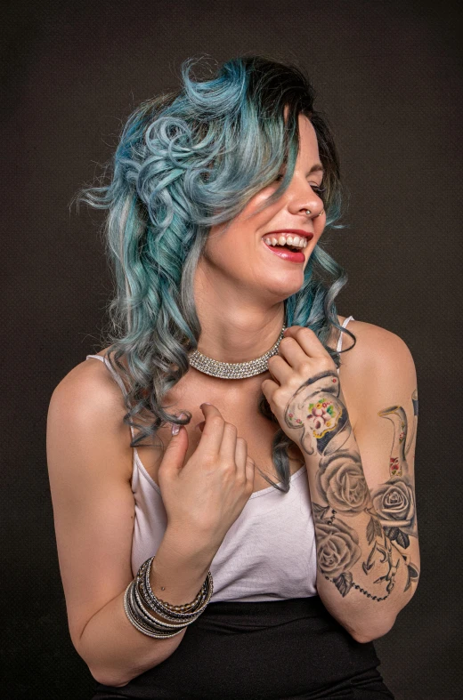 a woman with blue hair posing for a picture, a colorized photo, inspired by Elsa Bleda, trending on pexels, rococo, earing a shirt laughing, tattoo parlor photo, with curls, professional photo