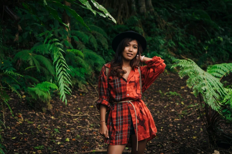 a woman standing in the woods talking on a cell phone, a portrait, pexels contest winner, sumatraism, tartan garment, tropical style, avatar image, outfit photo