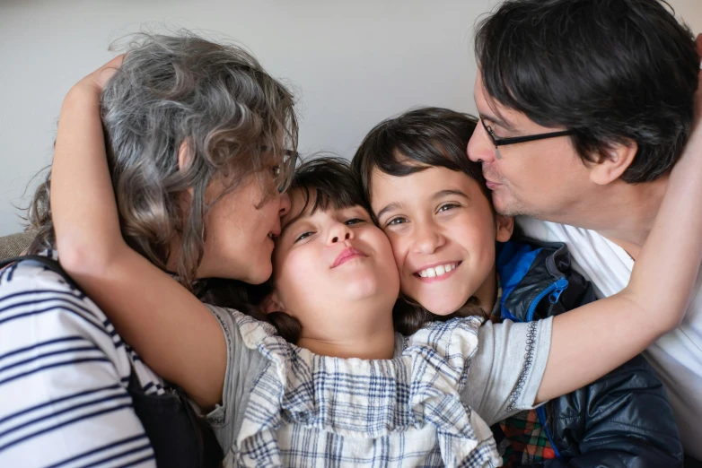 a group of people sitting on top of a couch, a picture, by Alison Geissler, pexels, incoherents, kissing smile, andy milonakis, close up portrait photo, mourning family