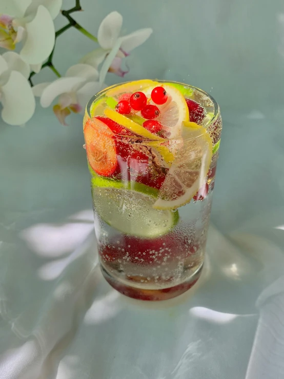 a glass filled with fruit sitting on top of a table, in water