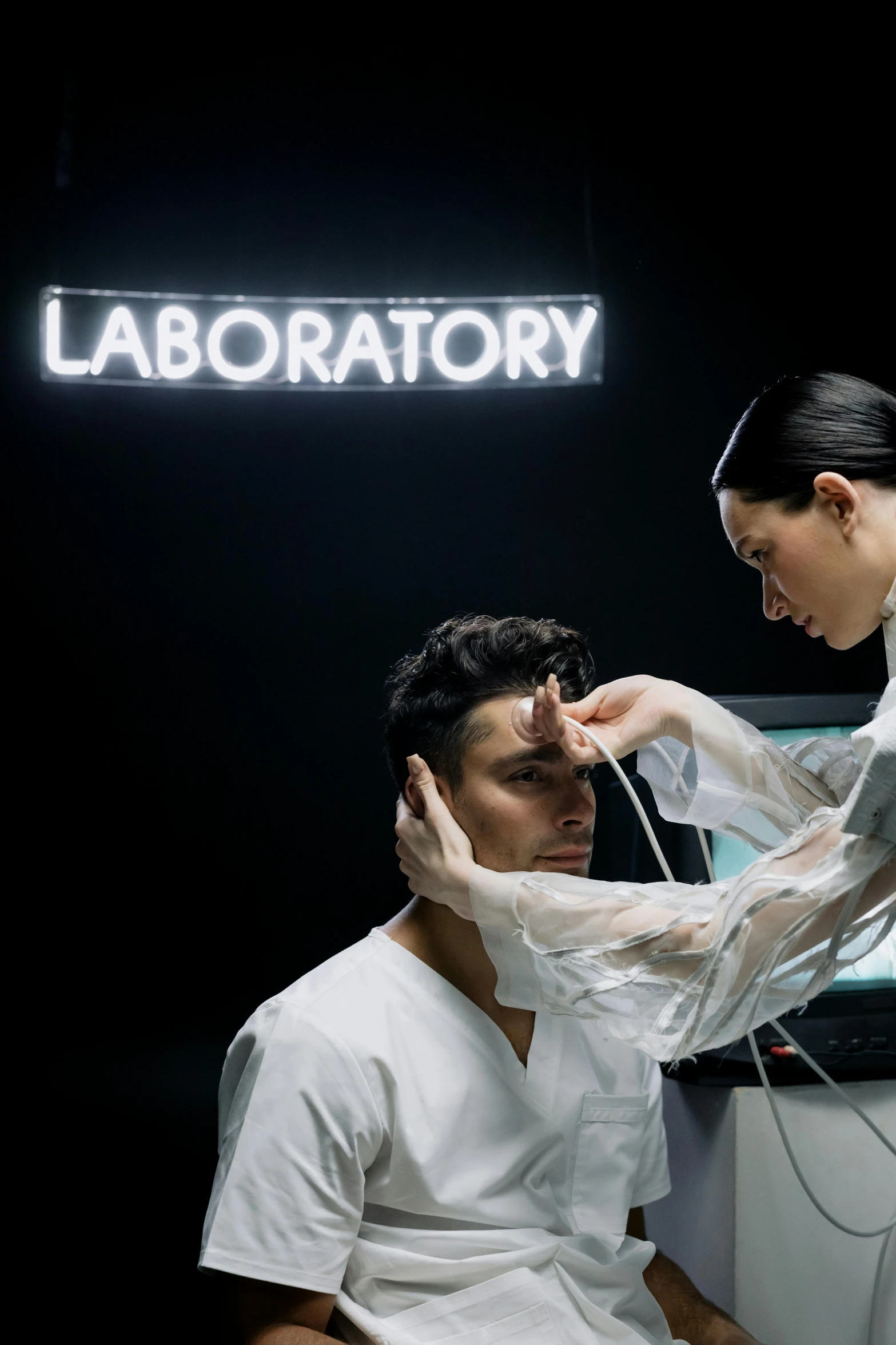 a woman standing next to a man in a lab, by Adam Marczyński, pexels contest winner, hyperrealism, hito steyerl, surgical gear, scene from bladerunner movie, hugh kretschmer