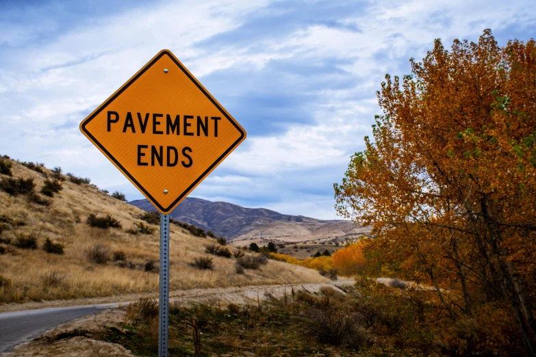 a yellow sign sitting on the side of a road, pexels contest winner, incoherents, paved roads, endings, ignant, half - turn