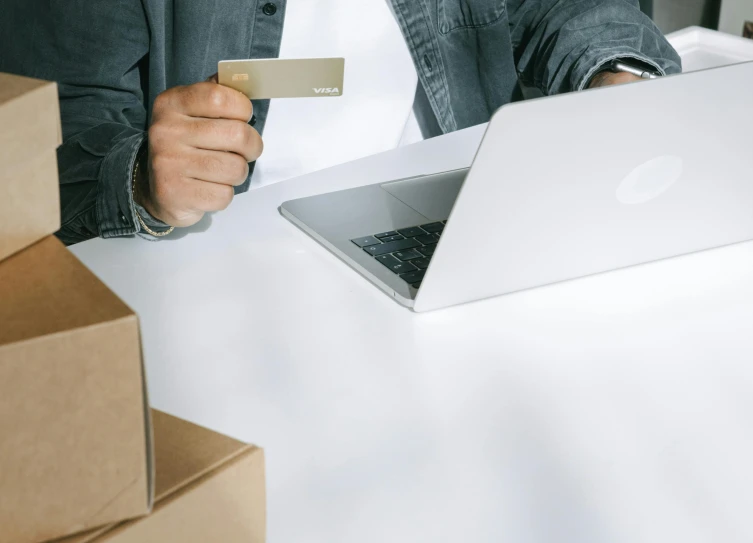 a man holding a credit card in front of a laptop, pexels contest winner, delivering parsel box, white-space-surrounding, thumbnail, wētā fx