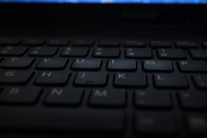 a close up of a keyboard on a laptop, by Carey Morris, pexels, computer art, panel of black, lit from below, low iso, where a large