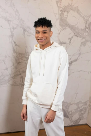 a man standing in front of a marble wall, an album cover, inspired by Louis Hersent, featured on instagram, renaissance, beige hoodie, non binary model, off - white collection, riyahd cassiem