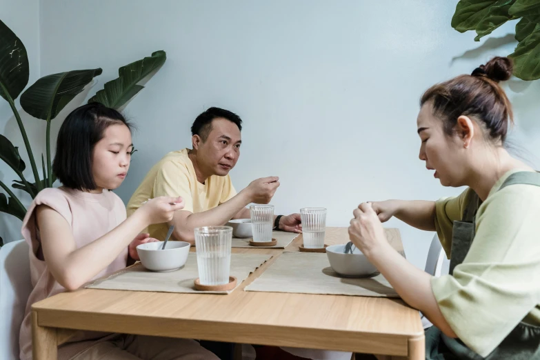 a group of people sitting around a wooden table, fatherly, eating noodles, avatar image, cinematic image