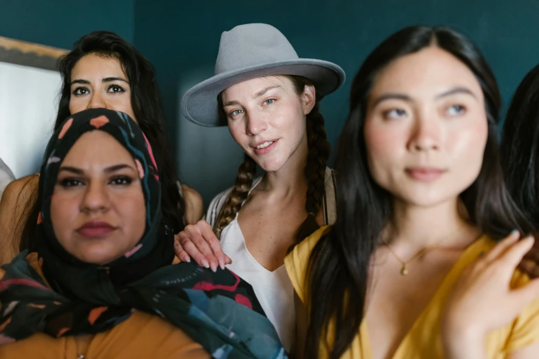 a group of women standing next to each other, a portrait, by Jessie Algie, trending on unsplash, hurufiyya, wearing hat, avatar image, half body photo, background image