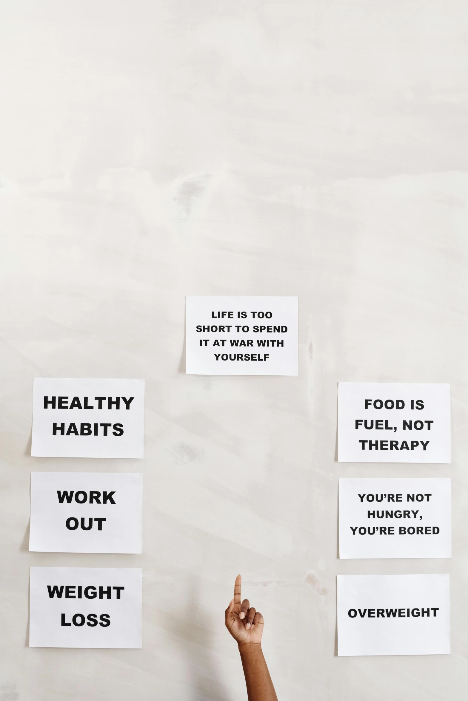 a person standing in front of a wall with signs on it, by Nina Hamnett, trending on pexels, healthy, on a white table, cards, black on white background