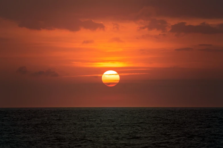 the sun is setting over the ocean, by Daniel Seghers, pexels contest winner, digital yellow red sun, bali, digital photo, round-cropped