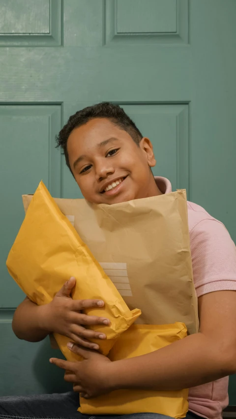 a boy sitting on a bench holding a paper bag, pexels contest winner, happening, delivering mail, at home, gold, closeup portrait