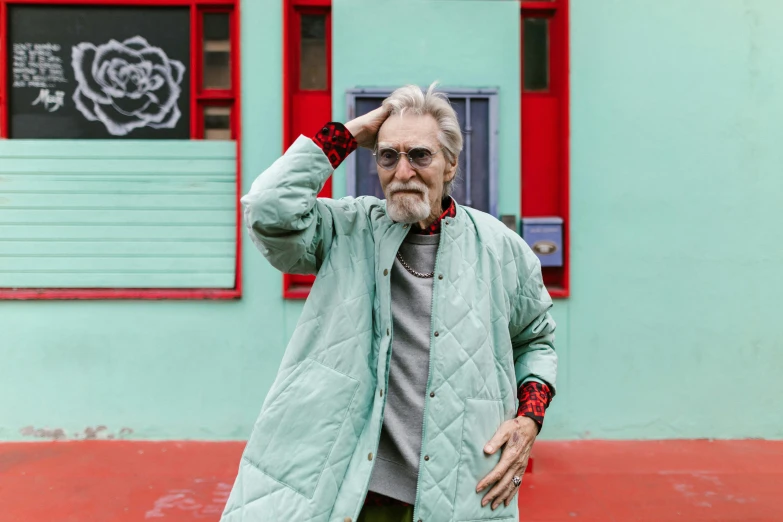 a man standing in front of a green building, inspired by Alasdair Gray, trending on pexels, maximalism, an old lady with red skin, stylish coat for a rave, oldman with mustach, peter capaldi