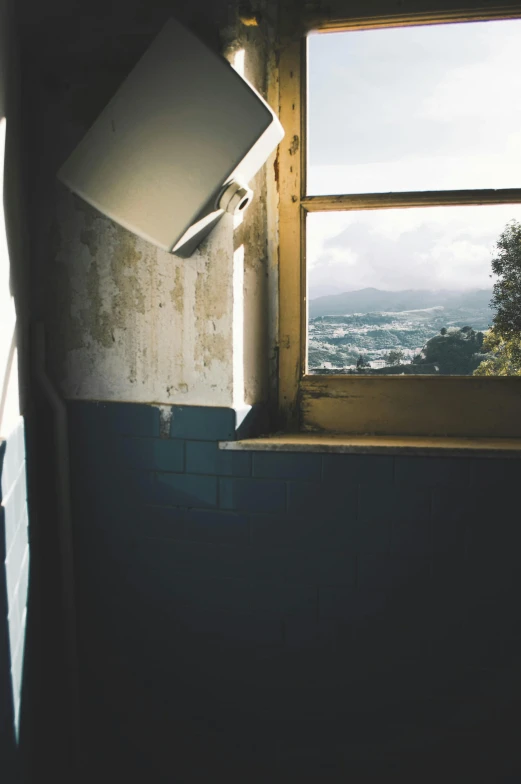 a television sitting on top of a window sill, a polaroid photo, unsplash, looking over west virginia, dirty room, lookout tower, bathed in light