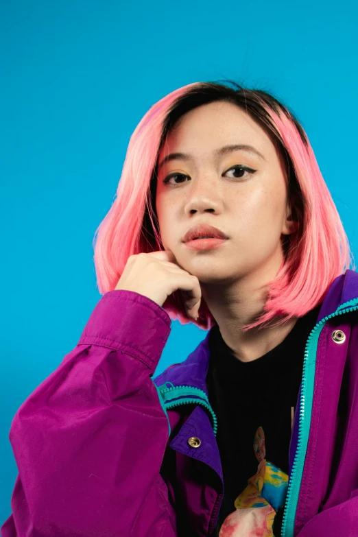 a woman with pink hair wearing a purple jacket, an album cover, inspired by Ruth Jên, trending on pexels, realism, half asian, magenta and crimson and cyan, studio portrait, woman in streetwear