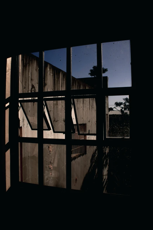 a view of a building through a window, an album cover, dramatic light darkroom, 1999 photograph, rust, a wooden