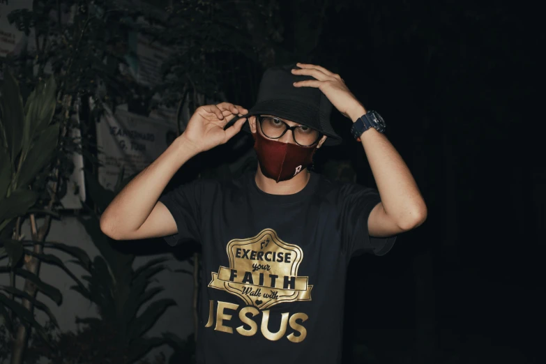 a man with a face mask covering his face, pexels contest winner, graffiti, jesus wasted at a party, t-shirt, beautiful gold saint, dark hat