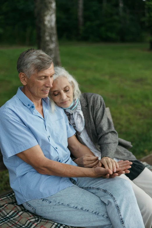 a man and a woman sitting on a bench, gray haired, holding each other hands, paul barson, thoughtful )