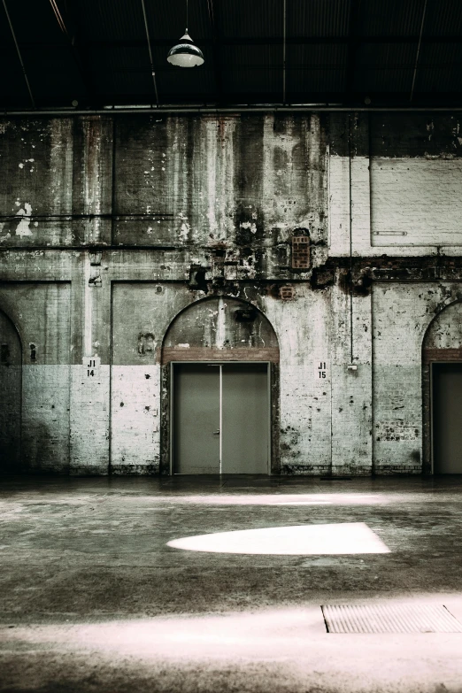 a black and white photo of an empty building, an album cover, inspired by Thomas Struth, unsplash contest winner, industrial colours, photo of a huge theaterstage, in an ancient vault, doors