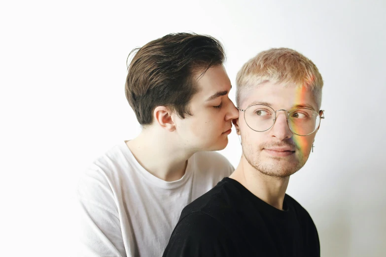 a couple of men standing next to each other, by Emma Andijewska, hand on cheek, pale complexion, transparent, roygbiv