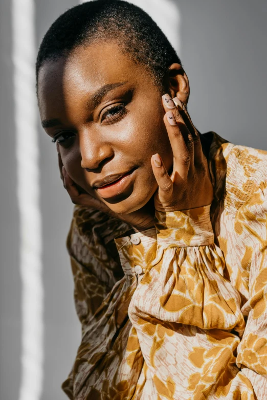 a close up of a person talking on a cell phone, wearing yellow floral blouse, brown skin. light makeup, sza, wearing two metallic rings