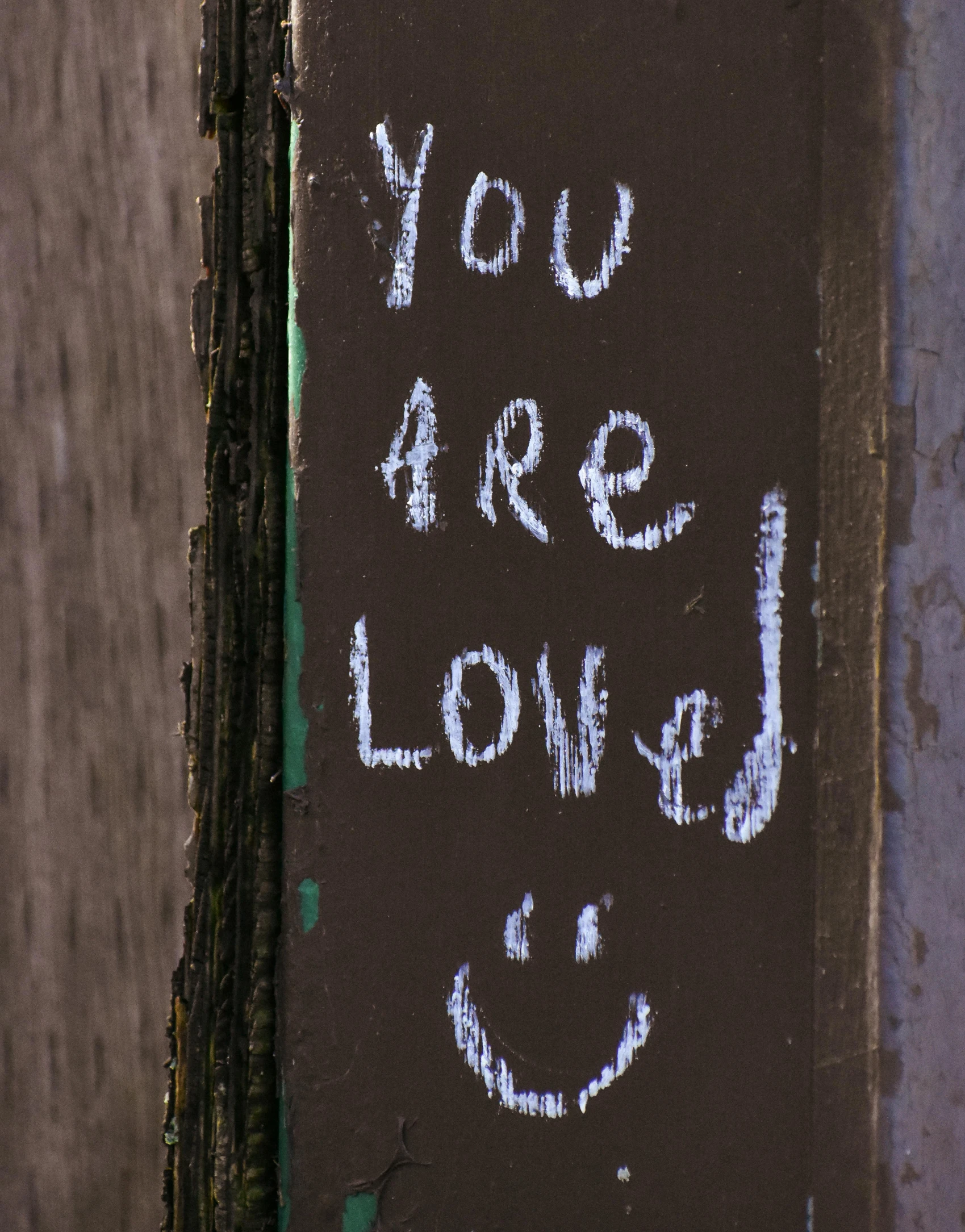 a sign with the words you are loved written on it, chalk art, by Attila Meszlenyi, trending on unsplash, graffiti, lgbt, paul barson, a still of a happy, listing image