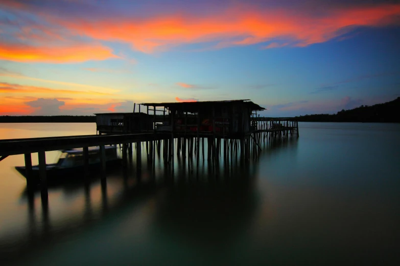 a boat sitting on top of a body of water, by Basuki Abdullah, pexels contest winner, hurufiyya, near a jetty, end of day, houses on stilts, slide show