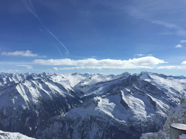 a person standing on top of a snow covered mountain, by Niko Henrichon, pexels contest winner, les nabis, panorama view of the sky, clear blue skies, viewed from bird's-eye, taken on an iphone