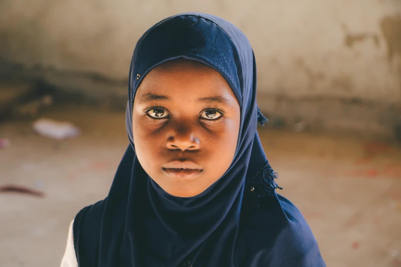 a close up of a person wearing a headscarf, by Daniel Lieske, unsplash contest winner, hurufiyya, light skinned african young girl, standing in class, indigo, timbuktu