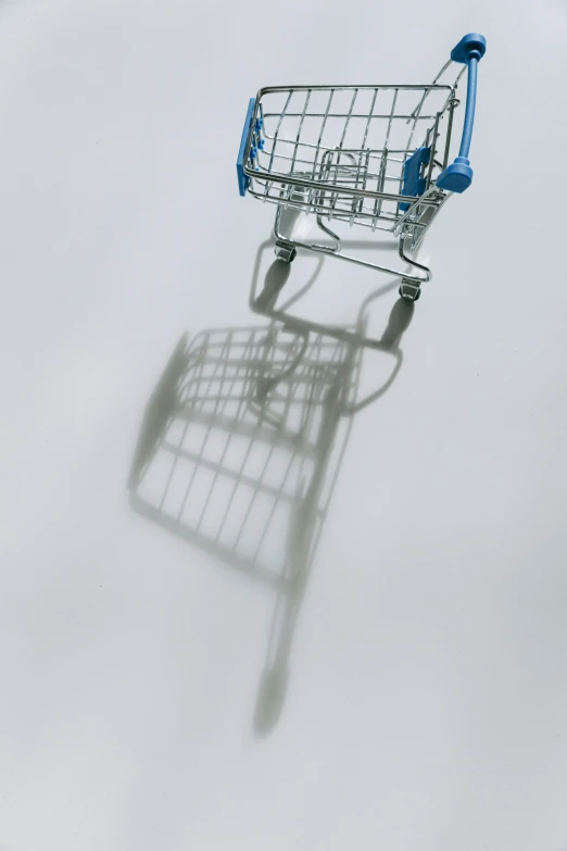 a shopping cart casting a shadow on a white surface, by Ben Zoeller, conceptual art, floating in mist, view from below, blues, n - 9