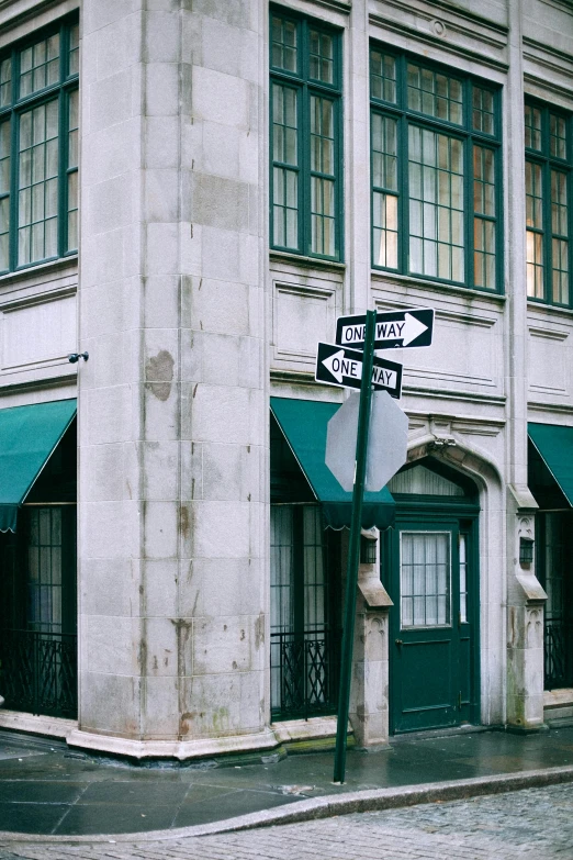 a street sign on a pole in front of a building, by Sven Erixson, trending on unsplash, tall arched stone doorways, ( ( dark green, new orleans, awnings