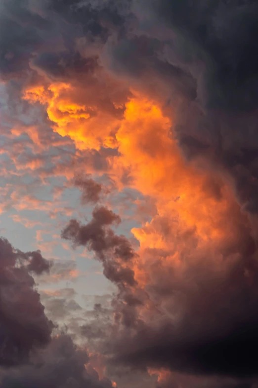 a plane flying through a cloudy sky at sunset, by Neil Blevins, dramatic sunset nebula, fire storm, tall, up close