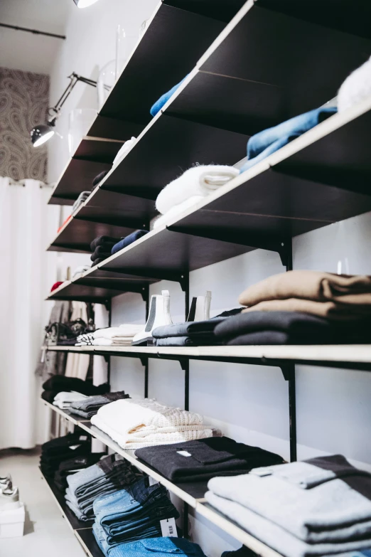 a walk in closet filled with lots of clothes, by Matija Jama, trending on unsplash, shelf, black show room, studio photo, thumbnail