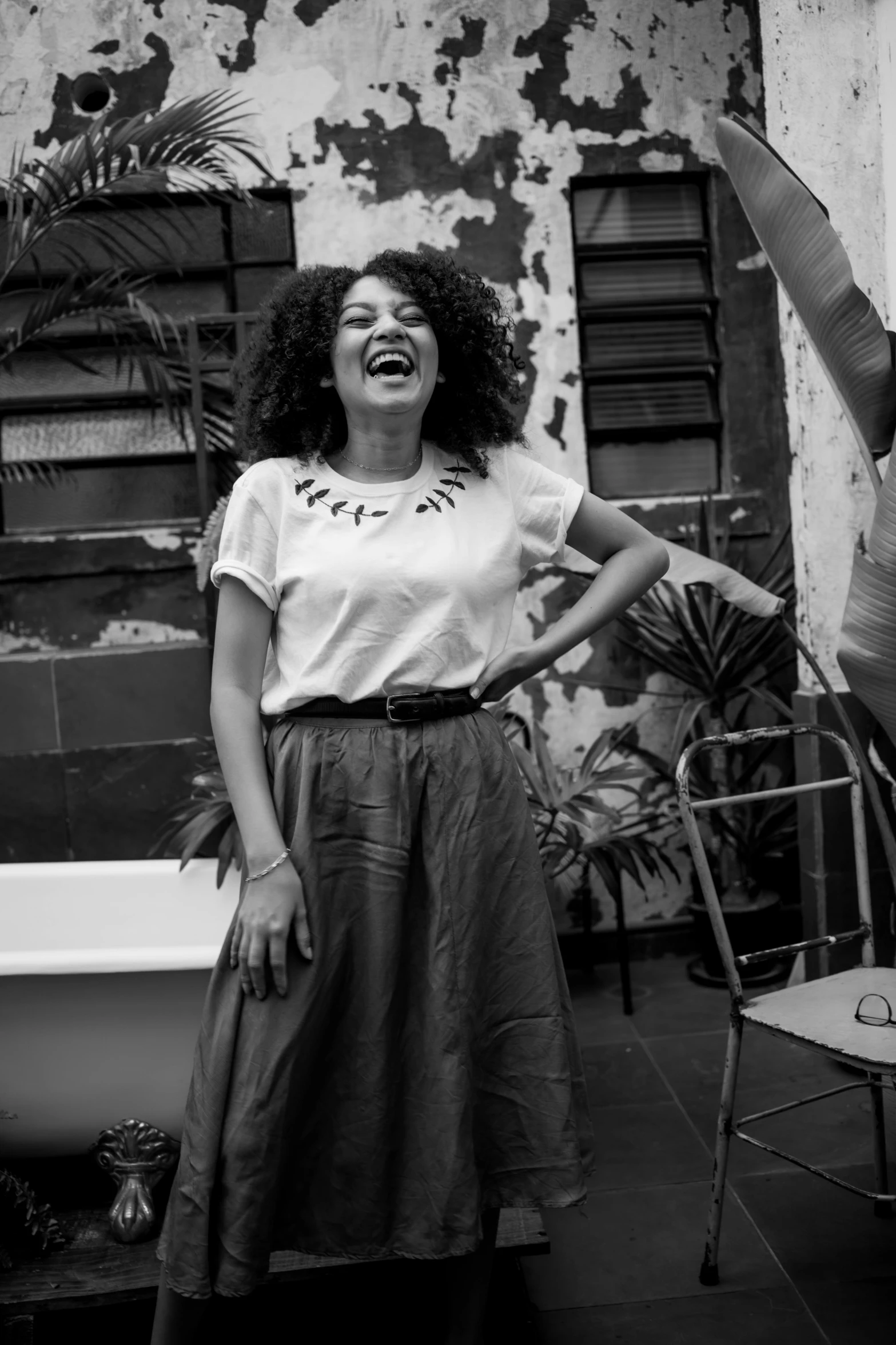 a black and white photo of a woman standing in front of a bathtub, inspired by Almeida Júnior, happening, both laughing, curly afro, promotional image, sao paulo