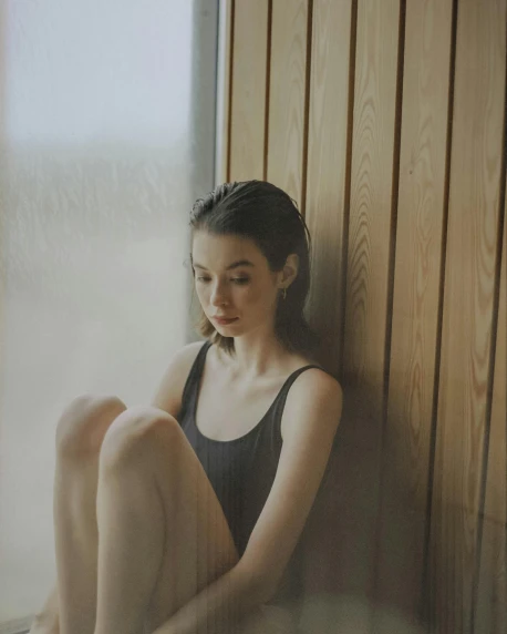 a woman sitting on the floor in front of a window, pexels contest winner, portrait sophie mudd, sauna, translucent skin, trending on vsco
