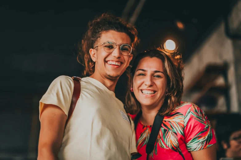 a couple of women standing next to each other, pexels contest winner, antipodeans, smiling at camera, revellers, amr elshamy, slight nerdy smile