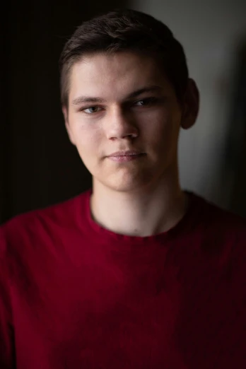 a close up of a person wearing a red shirt, by Jacob Toorenvliet, male teenager, portrait soft low light, professional headshot, paul barson