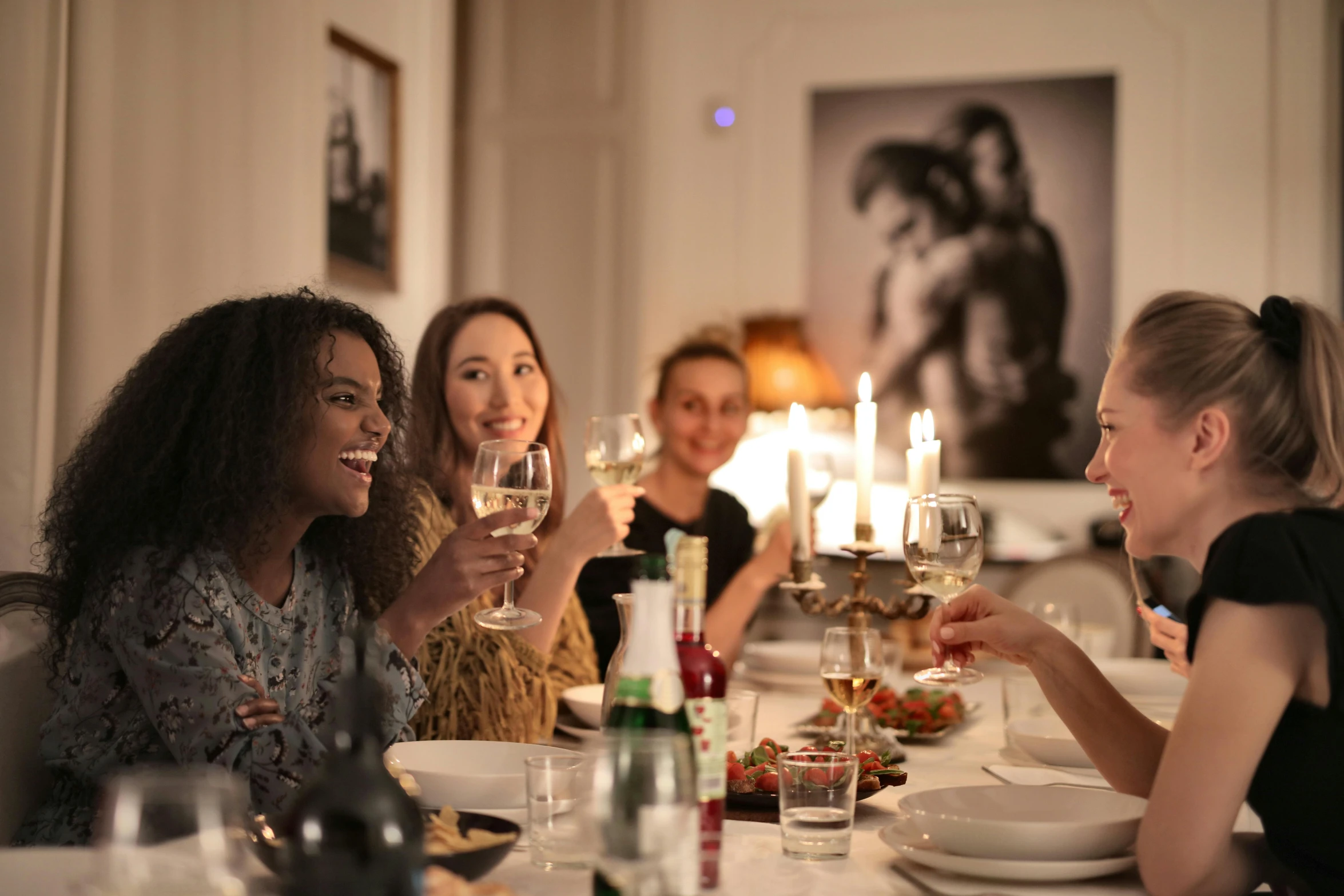 a group of women sitting at a table with wine glasses, food, profile image, hammershøi, close to night