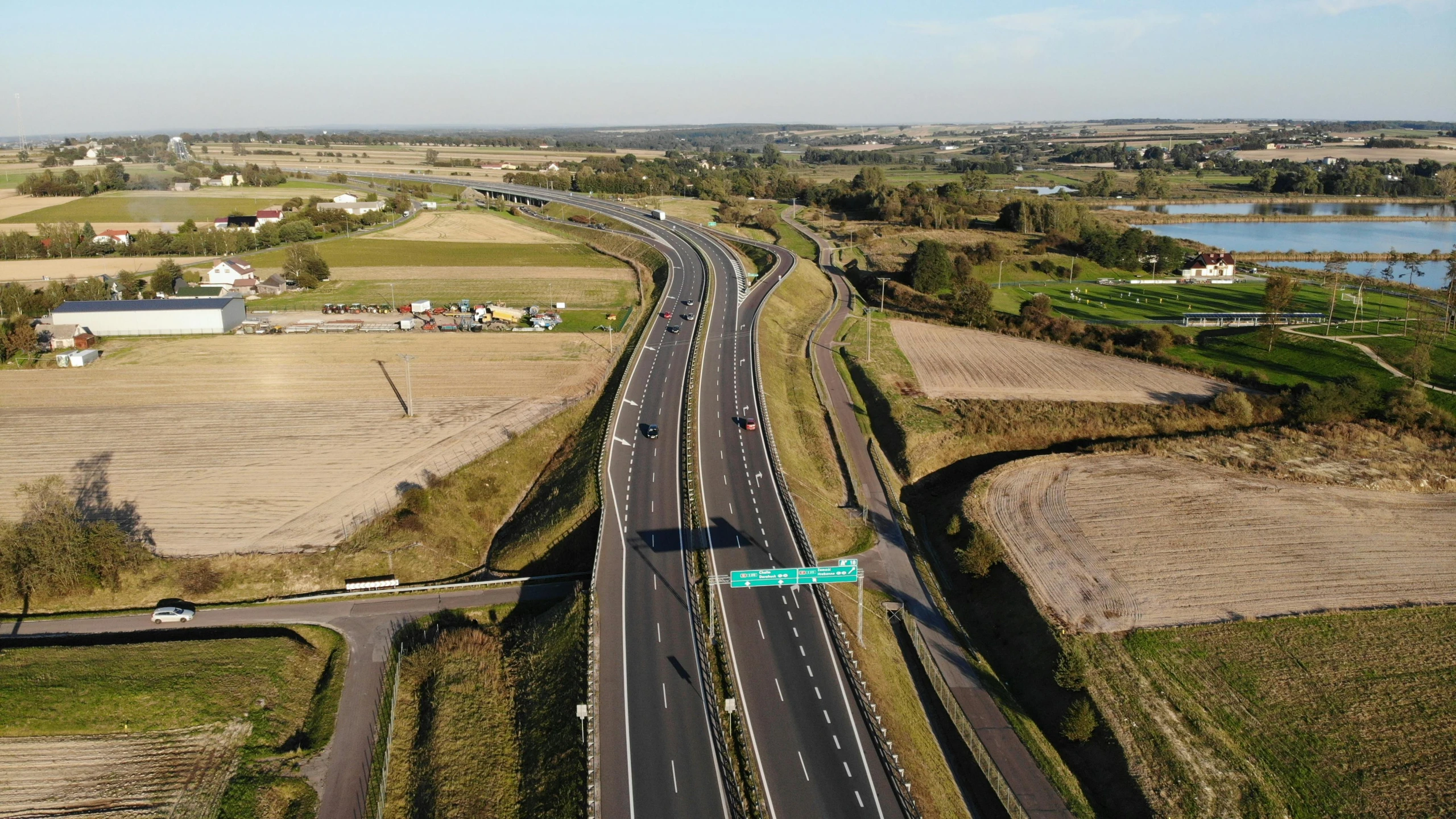 an aerial view of a highway in a rural area, by Julian Allen, 15081959 21121991 01012000 4k, high resolution ultradetailed, thumbnail, alex heywood