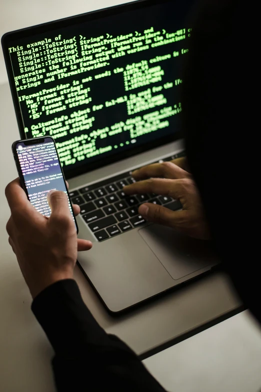 a person sitting in front of a laptop computer, hacking into the mainframe, taken on an iphone, 💣 💥💣 💥, android phones