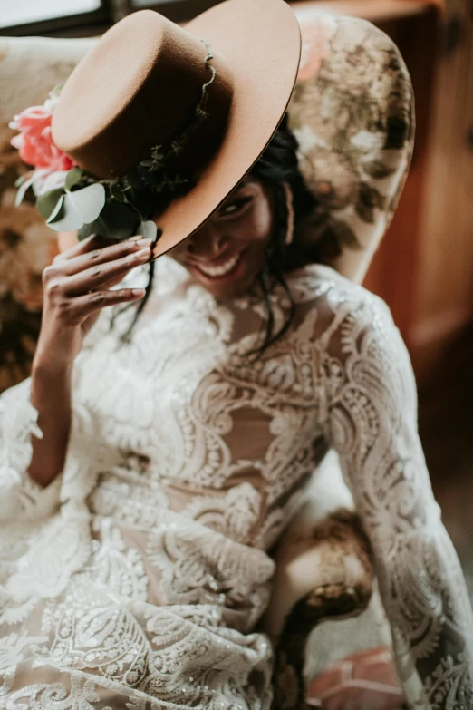 a woman sitting in a chair with a hat on her head, trending on unsplash, renaissance, wedding dress, cowboy themed, floral details, brown