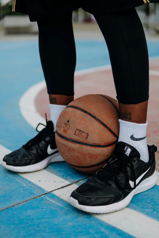 a person standing on a basketball court holding a basketball, trending on dribble, gray shorts and black socks, swoosh, pitch black skin, elaborate details